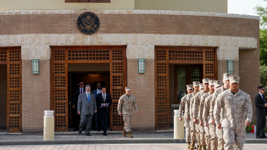 U.S. Secretary of State Marco Rubio holds a folded U.S flag as he walks with Steven Butler, charge d'affaires ad interim of the U.S. embassy in Kuwait, next to U.S. Marines during a flag raising ceremony at the embassy amid his visit to the Middle East to discuss the interim deal between the U.S. and Iran with Arab Gulf allies, in Kuwait City, Kuwait, June 24, 2026. REUTERS/Eric Lee/Pool
