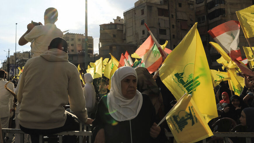 A woman holds a Hezbollah flag while commemorating Israel’s withdrawal from southern Lebanon in 2000, in Beirut's southern suburbs, Lebanon, May 25, 2026. REUTERS/Raghed Waked