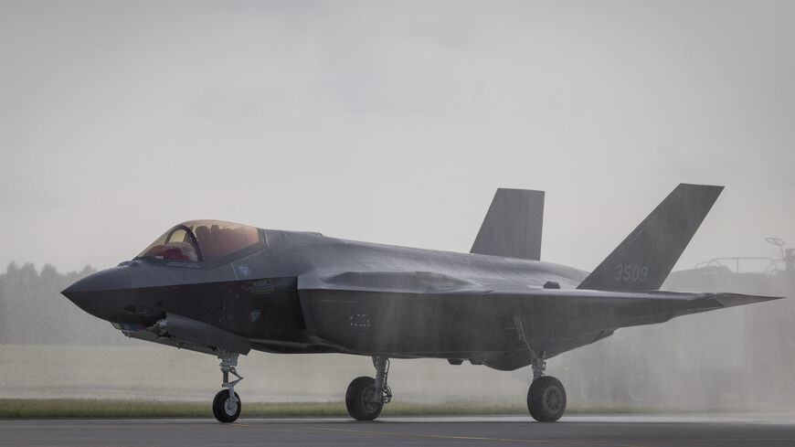 One of the first three US-made F-35 aircraft in Polish Air Force colors taxis along the runway at the 32nd Tactical Air Base in Lask, central Poland, while fire-fighting vehicles perform a water salute on May 22, 2026. 