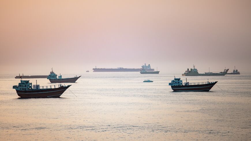 A tourist boat passes near crude oil tankers, bulk carriers, and other vessels anchored off Port Sultan Qaboos in Muscat, Oman, June 19, 2026. 