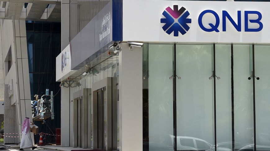 A picture taken on June 5, 2017, shows a man walking past the Qatar National Bank branch in the Saudi capital Riyadh. 