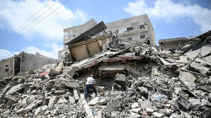 A man sifts through the rubble for his belongings in a building hit by Israeli strikes in the coastal Lebanese city of Tyre 