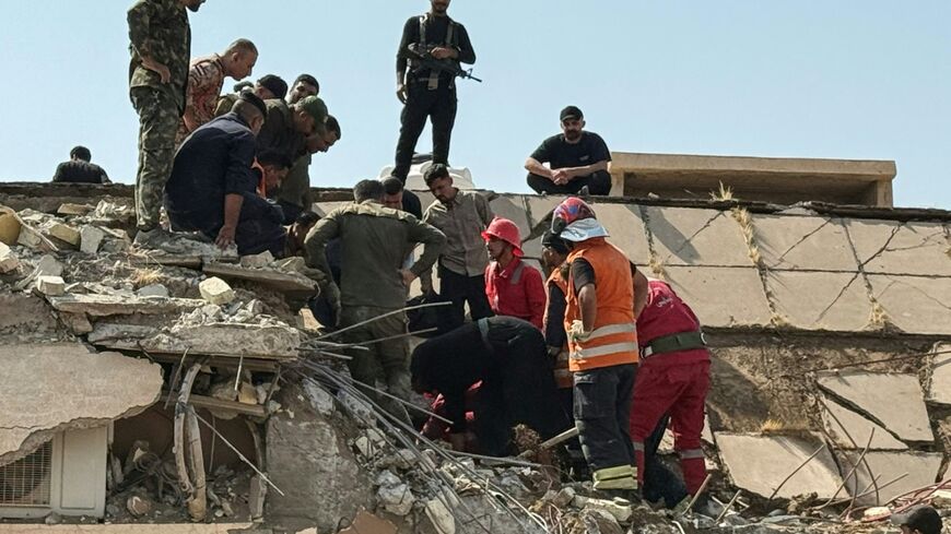Iraqi security forces and emergency personnel worked to recover the woudned at the site of US-Saudi strikes that targeted a base belonging to the Hashed al-Shaabi forces in Iraq's Diyala province