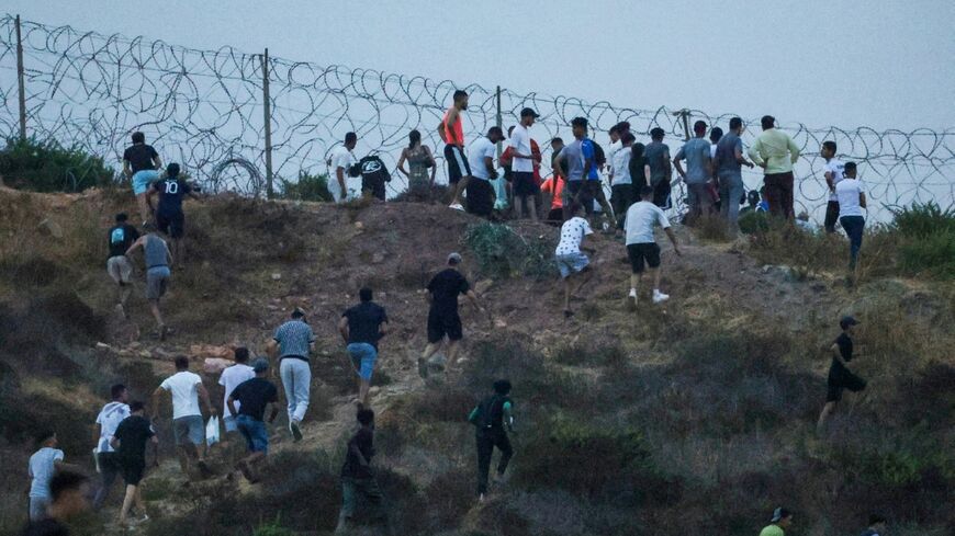 People seen gathering on hilltop on the Moroccan side of the border with Ceuta