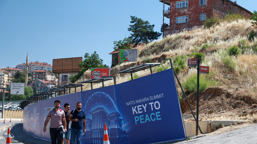 People walk past a billboard built for the upcoming NATO summit in Ankara, Turkey, July 1, 2026. REUTERS/Efekan Akyuz