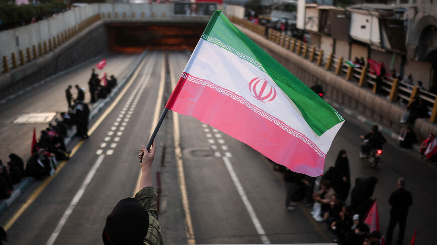 A mourner waves an Iranian flag on the day of the funeral procession for Iran's late Supreme Leader Ayatollah Ali Khamenei, who was killed on February 28 in Israeli and U.S. airstrikes, in Tehran, Iran, July 6, 2026.  REUTERS/Alkis Konstantinidis