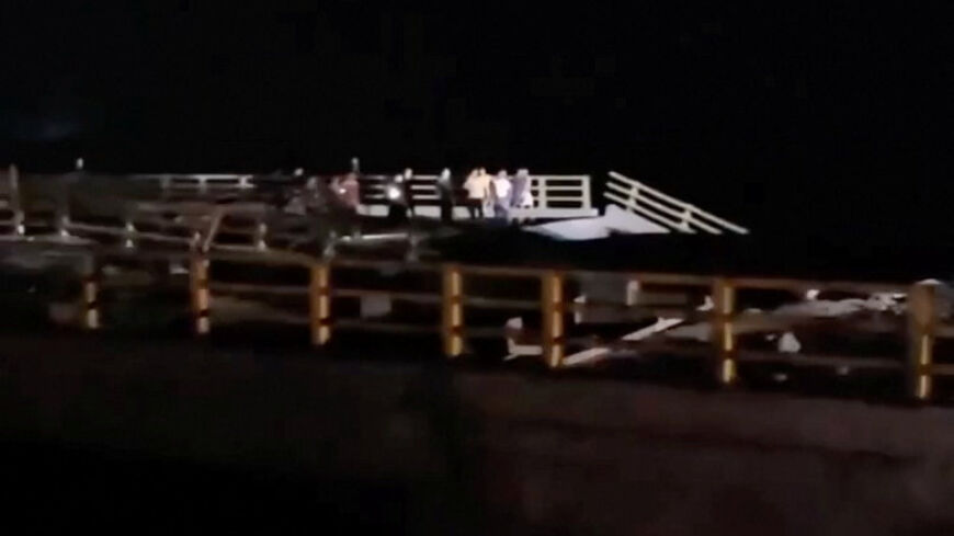 People stand near a damaged portion of a bridge in the aftermath of a strike, in Bandar Khamir, Hormozgan province, Iran July 16, 2026 in this screen grab obtained from social media video. Social Media/via REUTERS