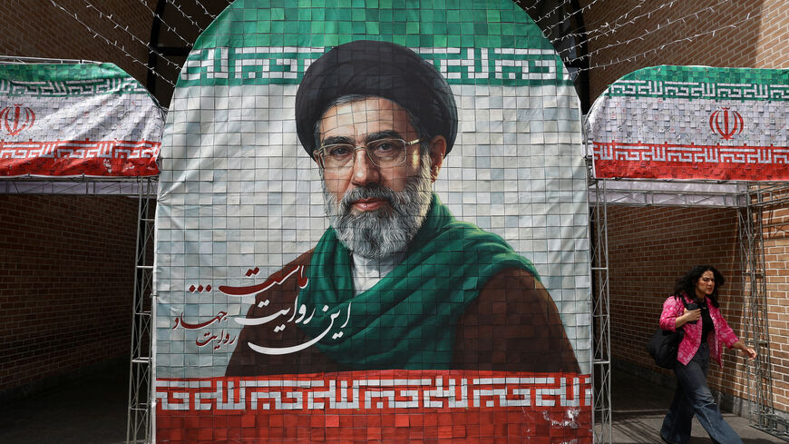 FILE PHOTO: A woman walks next to a banner with a picture of Iran's new Supreme Leader Mojtaba Khamenei in Tehran, Iran, May 8, 2026. Majid Asgaripour/WANA (West Asia News Agency) via REUTERS /File Photo
