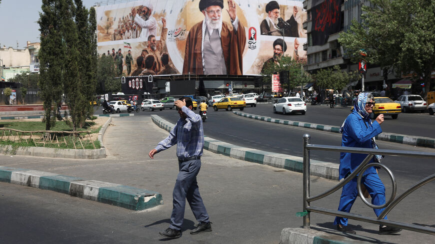 FILE PHOTO: People walk past a billboard featuring images of Iran's late Supreme Leader Ayatollah Ali Khamenei in Tehran, Iran, July 13, 2026. Majid Asgaripour/WANA (West Asia News Agency) via REUTERS/File Photo
