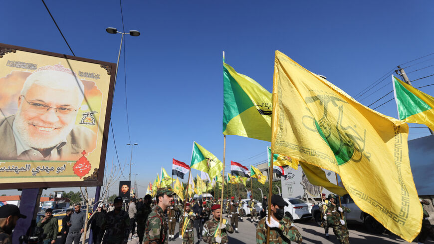 Fighters lift flags of Iraq and paramilitary groups, including al-Nujaba and Kataib Hezbollah, during a funeral in Baghdad for five militants killed a day earlier in a US strike in northern Iraq, on Dec. 4, 2023. 