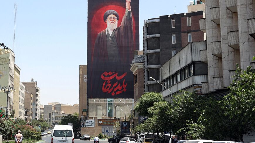 Motorists drive past a billboard bearing a picture of Iran's slain supreme leader Ali Khamenei, ahead of his funeral in Tehran on July 3, 2026. Iranian leaders began paying their respects on July 3 before the coffin of the country's late supreme leader Ali Khamenei, killed in the US-Israeli strikes that triggered the Middle East war, as Tehran prepared for a vast funeral. Khamenei's body arrived at Tehran's Grand Mosalla on July 3 ahead of ceremonies which are expected to draw millions. (Photo by AFP via Ge