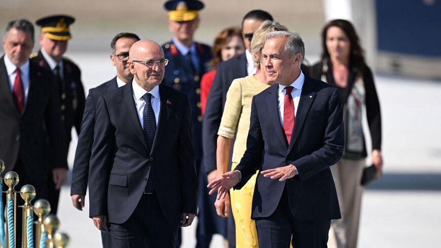 Canada's Prime Minister Mark Carney (R) is welcomed by Turkey's Treasury and Finance Minister Mehmet Simsek upon arrival at Esenboga Airport to attend the 36th NATO Heads of State and Government Summit in Ankara on July 7, 2026. (Photo by Muhammed Abdullah Kurtar / POOL / AFP via Getty Images)