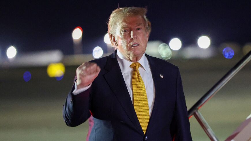 US President Donald Trump gestures as he steps off Air Force One to board the new Qatari-gifted Boeing plane, en route to the United States following his participation in the NATO Summit at Royal Air Force Mildenhall on July 8, 2026, in Mildenhall, England. 