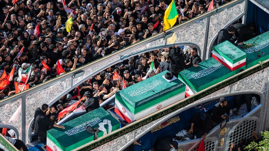Mourners surge towards the turban-clad casket of Iran's slain Supreme Leader Ayatollah Ali Khamenei on July 9, 2026, in Mashhad, Iran. 