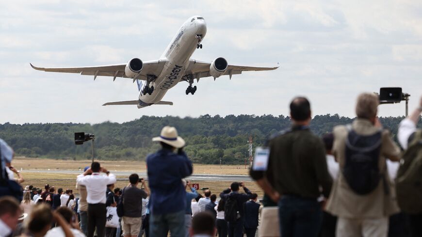 Spectators look on as an A350-1000 by the European plane maker Airbus takes off on the second day of the Farnborough International Airshow 2026, Farnborough, July 21, 2026.