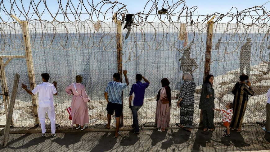 Relatives and friends wait at the border crossing for the return of people who crossed into Spain's North African exclave of Ceuta,