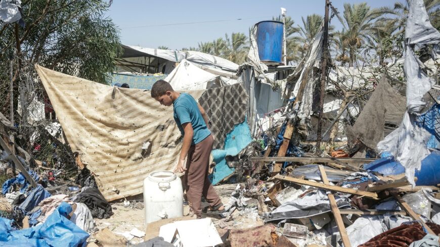 A displaced Palestinian youth inspects the damage of an alleged Israeli strike on a tent in Khan Yunis, in the southern Gaza Strip