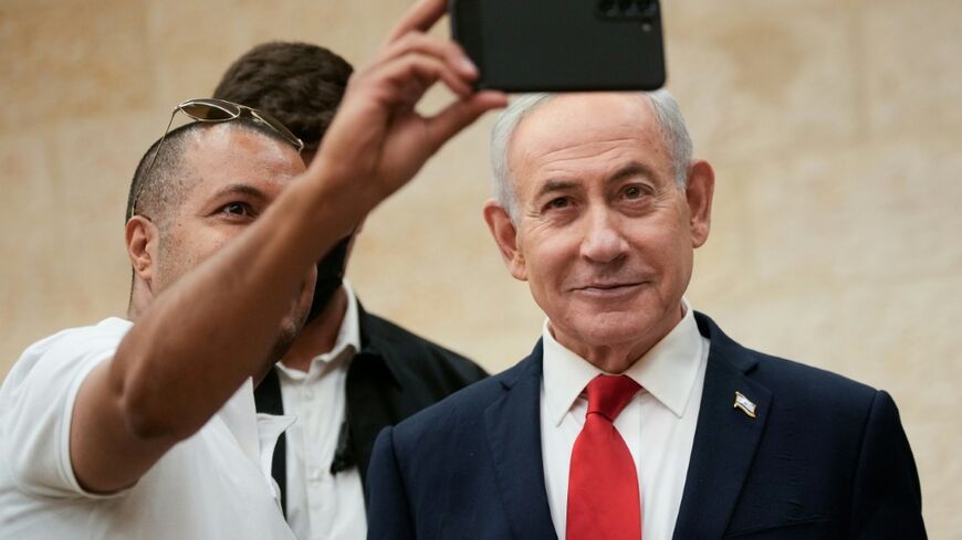 Israeli Prime Minister Benjamin Netanyahu takes a selfie with a supporter as he arrives to cast his ballot during his Likud party's primary elections on August 17, 2026