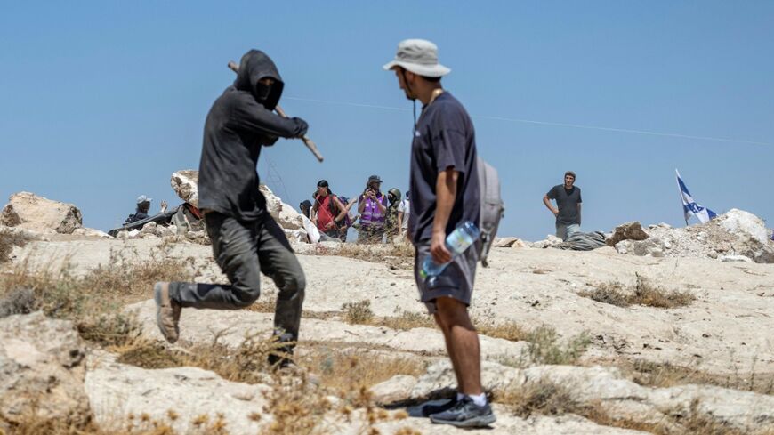 An Israeli settler attacks a left-wing activist who came to protect Palestinians at the illegal Israeli outpost of Jannatah
