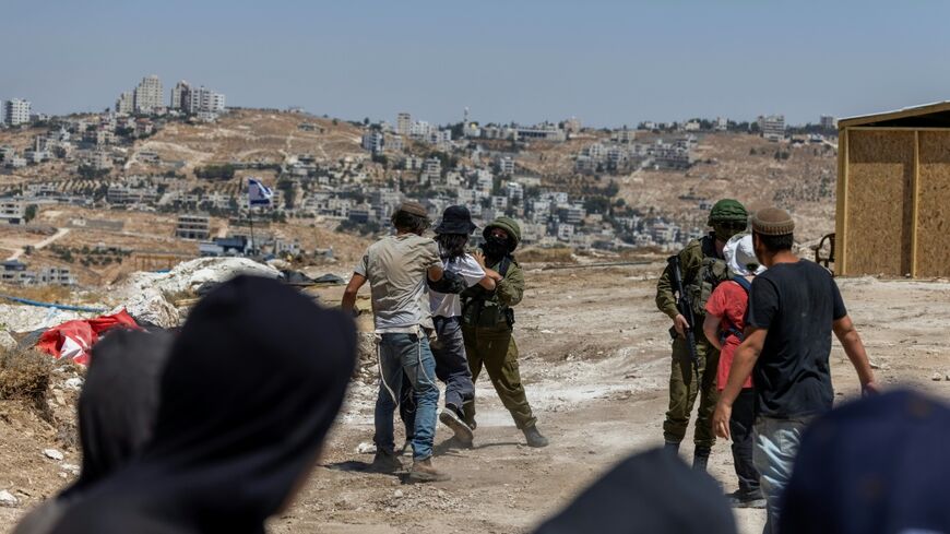 Israeli left-wing activists and Israeli settlers scuffle as Israeli security intervenes at an Israeli outpost in the Palestinian village of Jannatah, just south of the city of Bethlehem in the occupied West Bank
