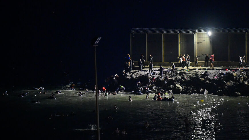 Migrants from Morocco cross into Ceuta by sea as other gather near the border fence between the Spanish enclave of Ceuta and Morocco, as seen from Ceuta, Spain, July 30, 2026. REUTERS/Fabian Bimmer