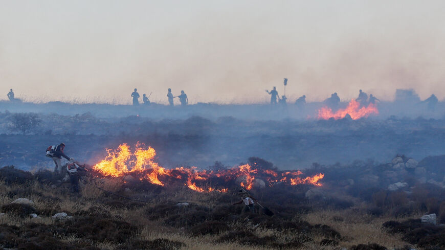 Israeli settlers put out a fire by a settler outpost, near the Palestinian town Taybeh in the Israeli-occupied West Bank, July 17, 2026. REUTERS/Ammar Awad