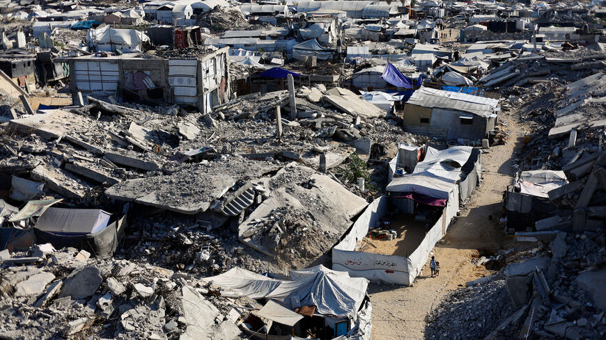 Palestinian children walk past the rubble of residential buildings destroyed during the war, at Jabalia refugee camp in the northern Gaza Strip, August 5, 2026. REUTERS/Mahmoud Issa