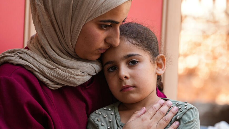 Palestinian Ruqaya Hassan Abu Reeda, 28, hugs her daughter at her father-in-law's house after Israeli settlers besieged her house in Qusra village in the Israeli-occupied West Bank, August 12, 2026. REUTERS/Ismael Khader