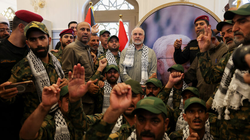 Iranian Parliament Speaker Mohammad Baqer Qalibaf stands with members of Iraq's Popular Mobilization Forces at the grave of Iraqi paramilitary commander Abu Mahdi al-Muhandis, who was killed alongside Iranian military commander Qassem Soleimani in a U.S. drone strike near Baghdad International Airport in January 2020, in Najaf, Iraq, August 21, 2026. REUTERS/Ahmed Saad