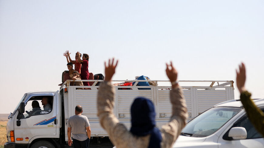 People wave to Kurds displaced during Syria's civil war who make their way to their hometown of Ras al-Ain (Sere Kaniye) under a January 2026 agreement between the Syrian Democratic Forces (SDF) and the Syrian government, in Hasakah, Syria, August 10, 2026. REUTERS/Orhan Qereman