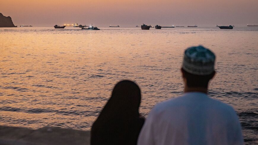 A couple watch oil tankers