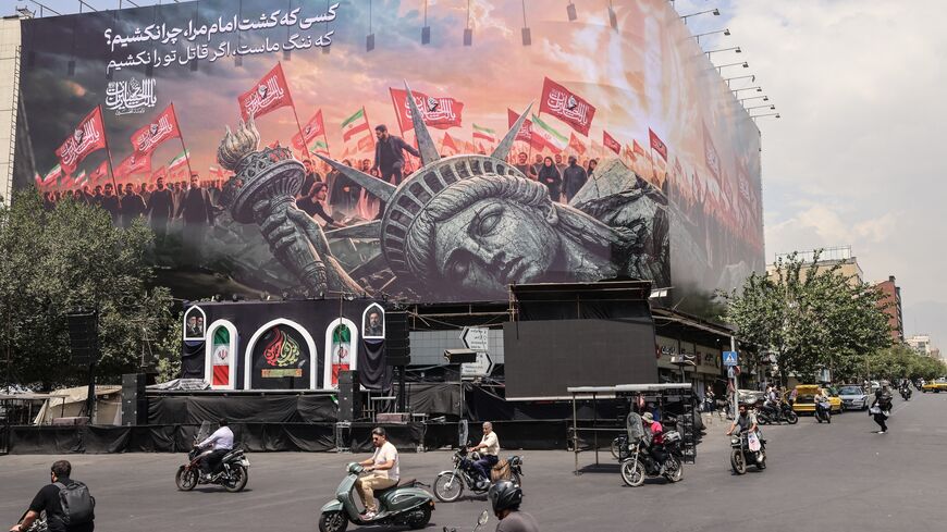 Iranians drive past an anti-US billboard at Enghelab Square in central Tehran, Aug. 3, 2026.