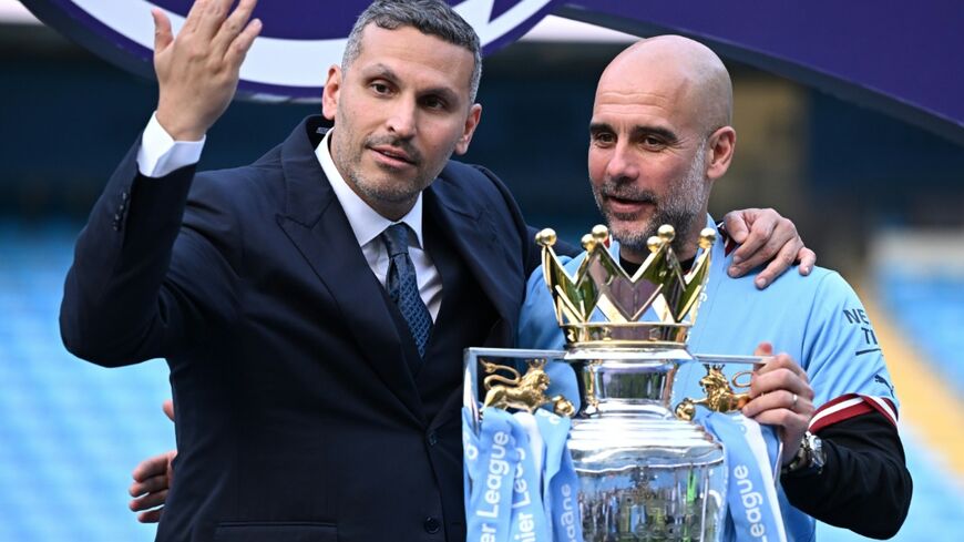 Manchester City's then-manager Pep Guardiola (R) with the club's Emirati chairman Khaldoon al-Mubarak at the presentation of the Premier League trophy in 2023
