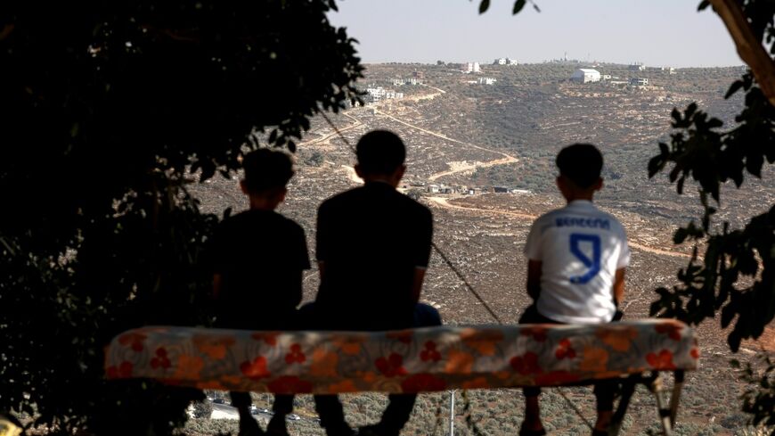 Palestinian boys looking towards a new illegal Israeli outpost in the West Bank