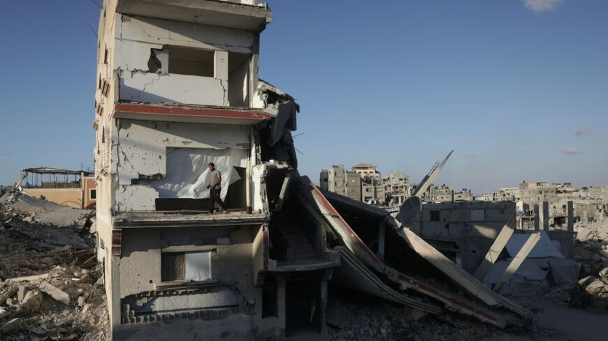 A displaced Palestinian man stands on the balcony of a heavily damaged building still used as shelter in Khan Yunis in the southern Gaza Strip on September 19, 2026