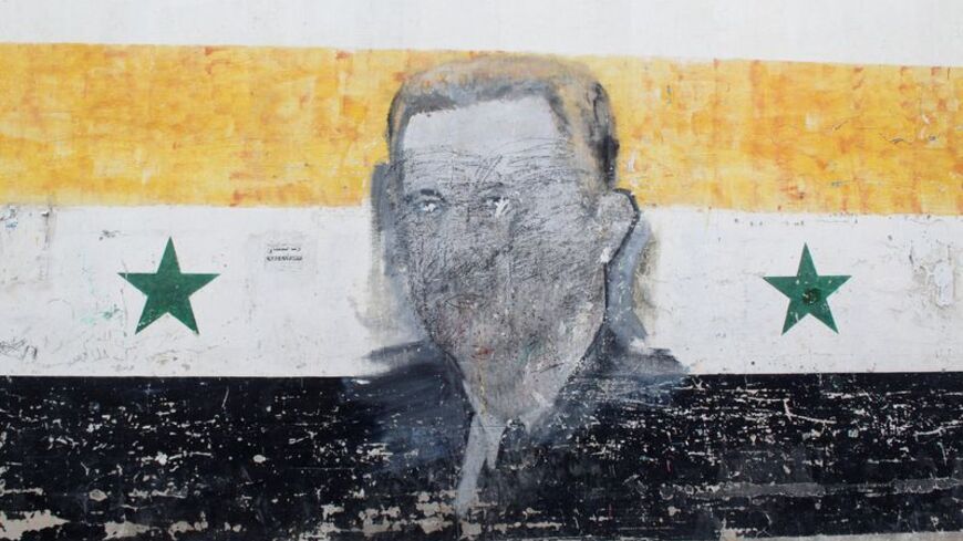 A wall painted with a damaged drawing of ousted Syrian President Bashar al-Assad is pictured in the al-Qadam neighbourhood' in Damascus