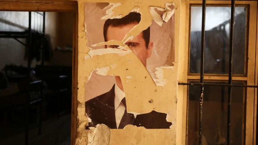 FILE PHOTO: A damaged portrait of former Syrian President Bashar al-Assad at a military base in Damascus