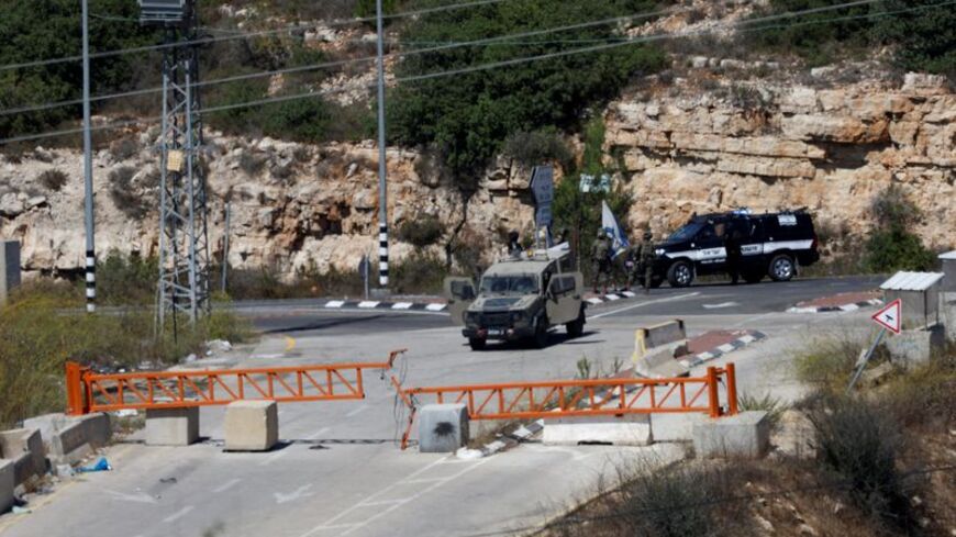 Israeli forces block a checkpoint after a shooting attack, near Ramallah