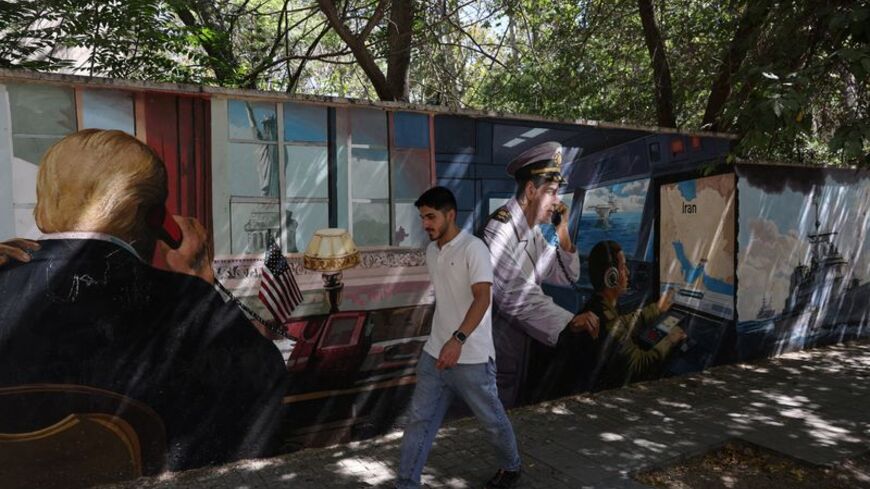 A man walks past an anti-U.S. mural in Tehran