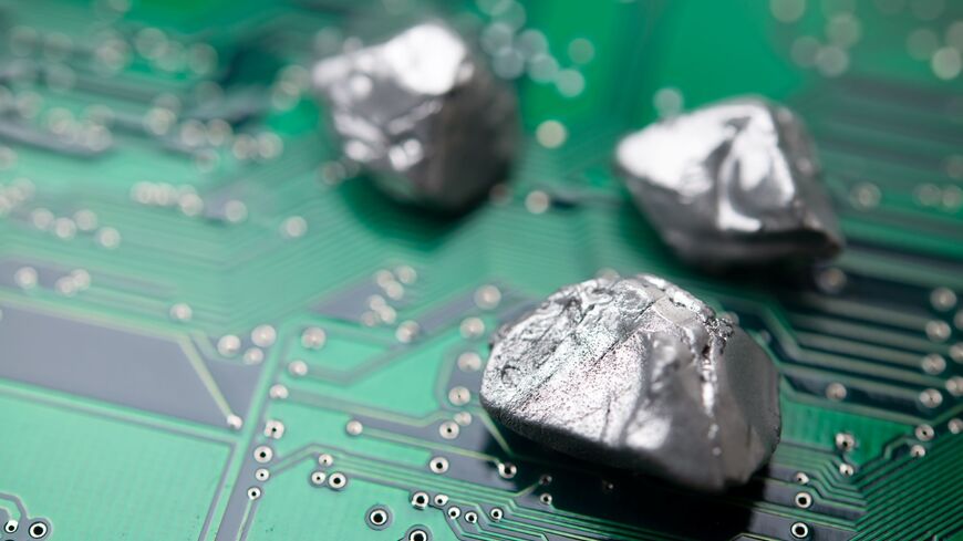 Rare earth mineral on a green electronic circuit board. — Getty Images stock photo
