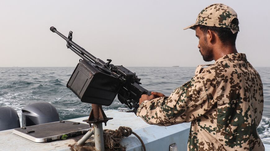 A sailor from the navy of Yemen's Aden-based internationally recognized government stands at a machine-gun position aboard a vessel patrolling a shipping lane off Hanish Island in the Red Sea on July 27, 2026.