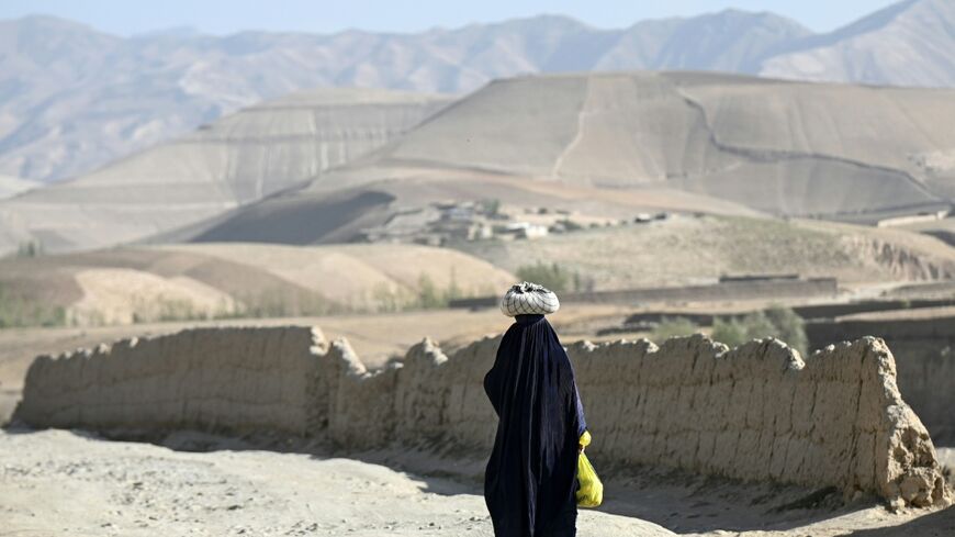 An Afghan burqa-clad woman walking along a road in the Argo district of Afghanistan's Badakhshan province
