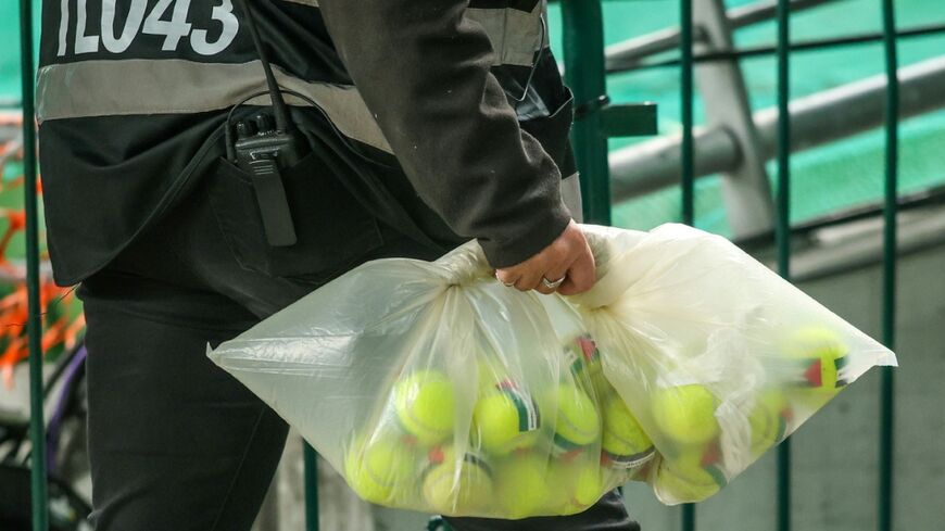 An official collects tennis balls with Palestinian flag stickers thrown onto the pitch during Ireland's game with Austria in Dublin