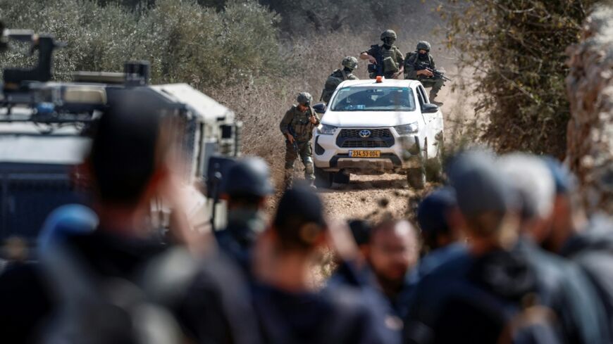 Israeli soldiers enter an olive grove as Palestinian farmers and foreign activists carry out a harvest in the village of Turmus Ayya, northeast of Ramallah