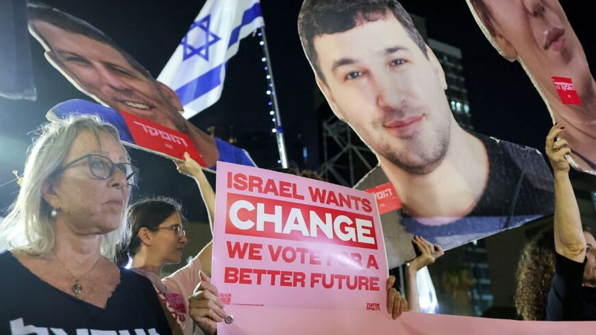 Protesters gather with signs during an anti-government demonstration demanding the formation of a state commission of enquiry into Hamas's October 7, 2023 attack at Hostages Square in Tel Aviv