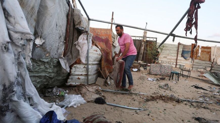 A Palestinian man inspects the site of an Israeli strike on a tent in Khan Younis