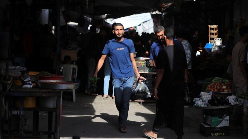 Palestinians walk through a street market in Gaza