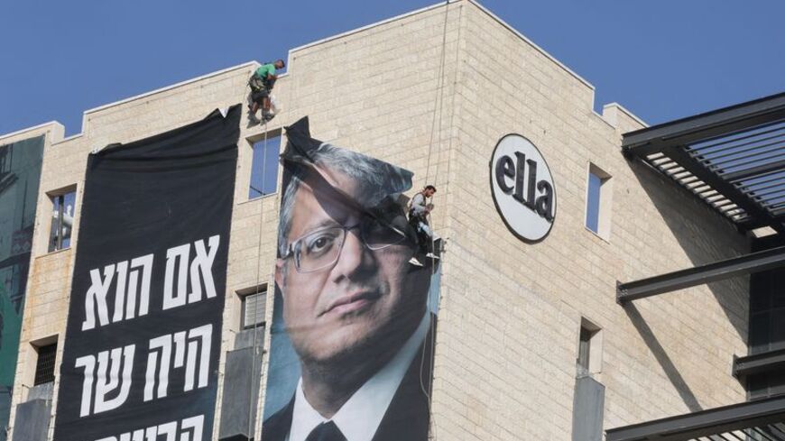 FILE PHOTO: Workers remove a banner featuring an image of Israel's National Security Minister Itamar Ben-Gvir, in Jerusalem