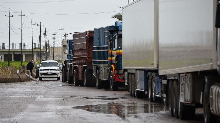 Trucks loaded with goods wait to cross over to Syria