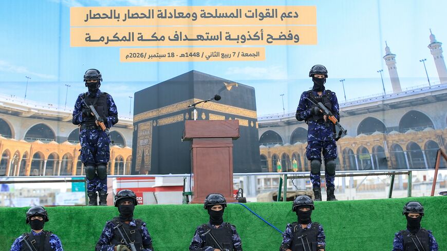 Security forces stand guard in front of a banner showing the Kaaba during a protest by supporters of the Houthi authorities against the Saudi intervention in Yemen and against Saudi Arabia's recent accusation that the Houthis fired at the holy city of Mecca, in Sanaa on Sept. 18, 2026. 
